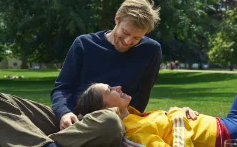 Una pareja sentada en un parque, mirándose con amor.