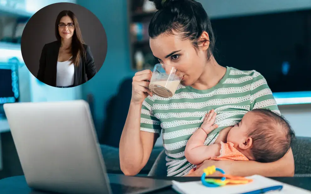 Una mamá dándole la teta a un bebé en frente a una computadora.