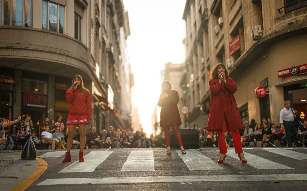 Mujeres vestidas de rojo en la ciudad haciendo una performance en la calle.