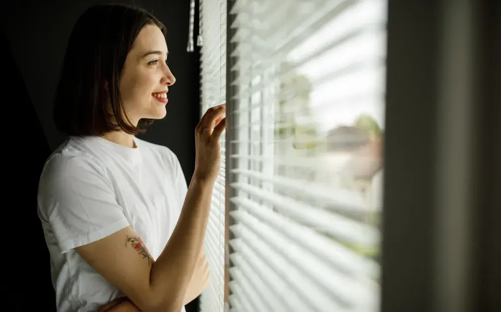 mujer mirando por la ventana