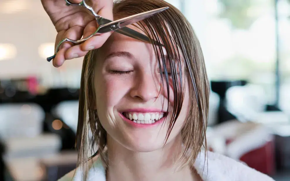 Una mujer cortándose el pelo en la peluquería