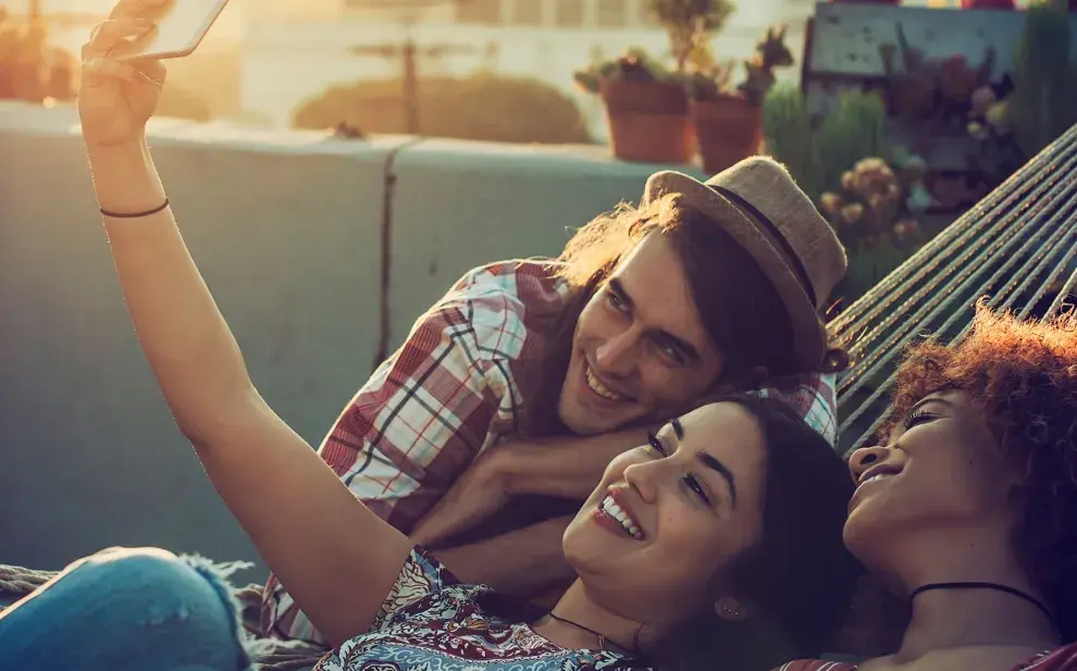 jóvenes sonriendo frente al celular