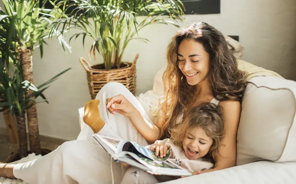 Una mamá y su hija hojeando juntas un libro