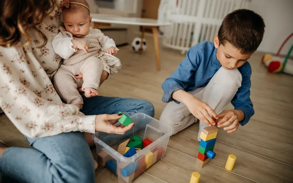 Madre juega con sus dos hijos.
