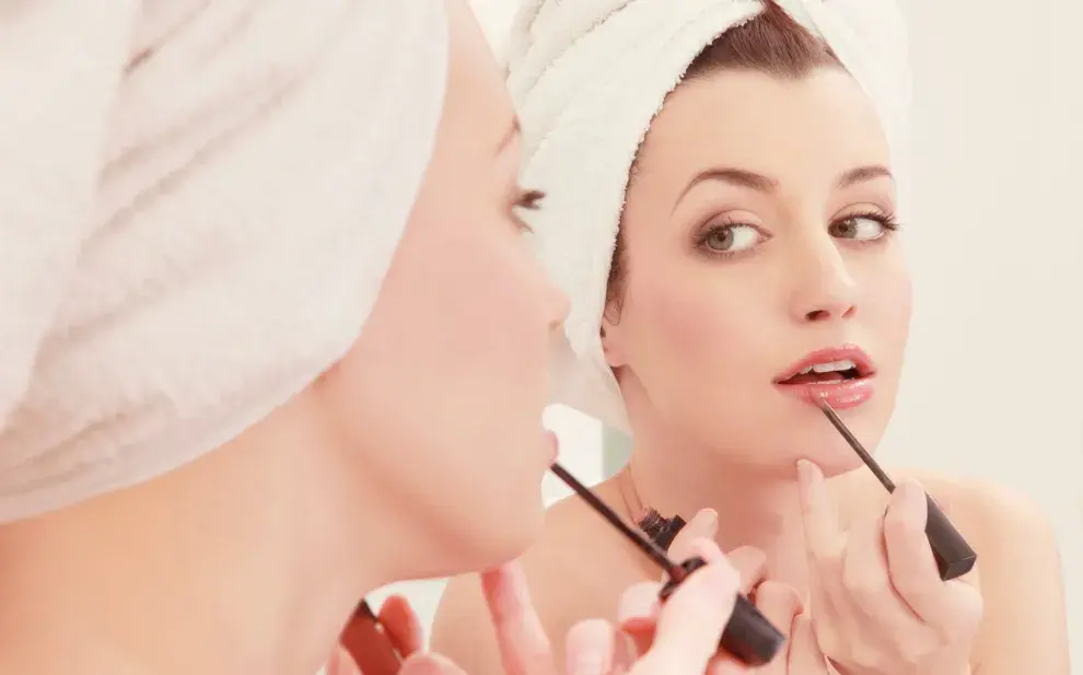 Foto de mujer maquillándose.